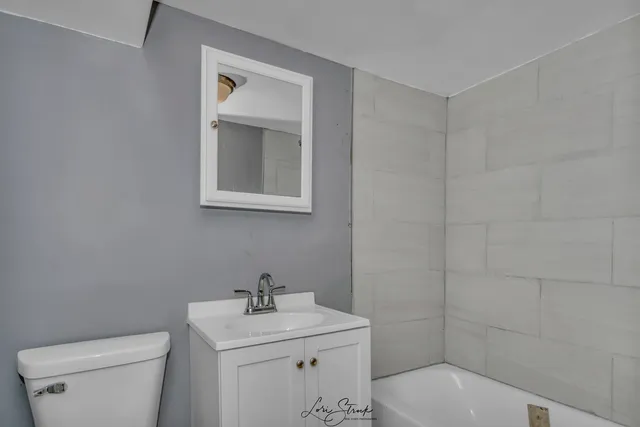 a bathroom with a toilet sink and mirror