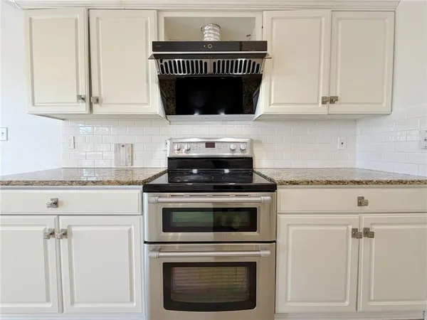 a kitchen with a sink dishwasher a stove top oven a counter space and cabinets