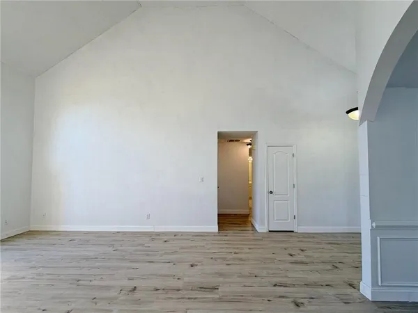 a view of empty room with wooden floor and ceiling fan