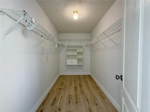 a view of a room with a ceiling fan and wooden floor