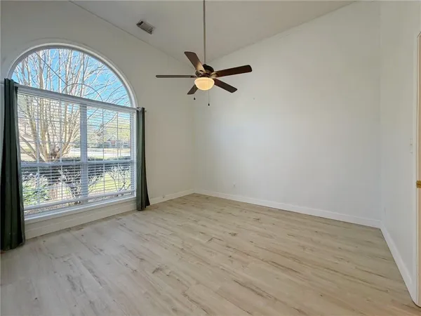an empty room with fan and windows