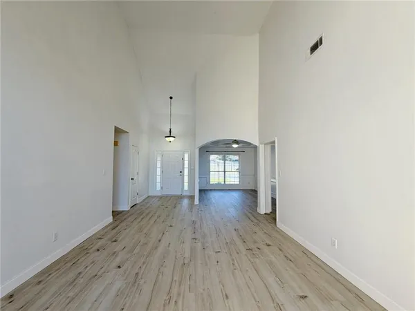 a view of empty room with wooden floor and window
