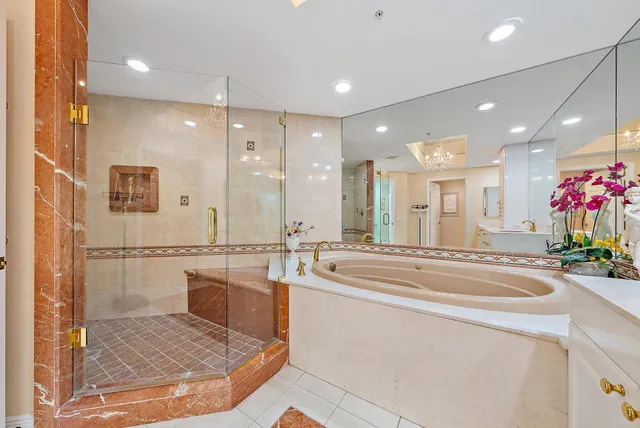 a spacious bathroom with a tub sink shower and mirror