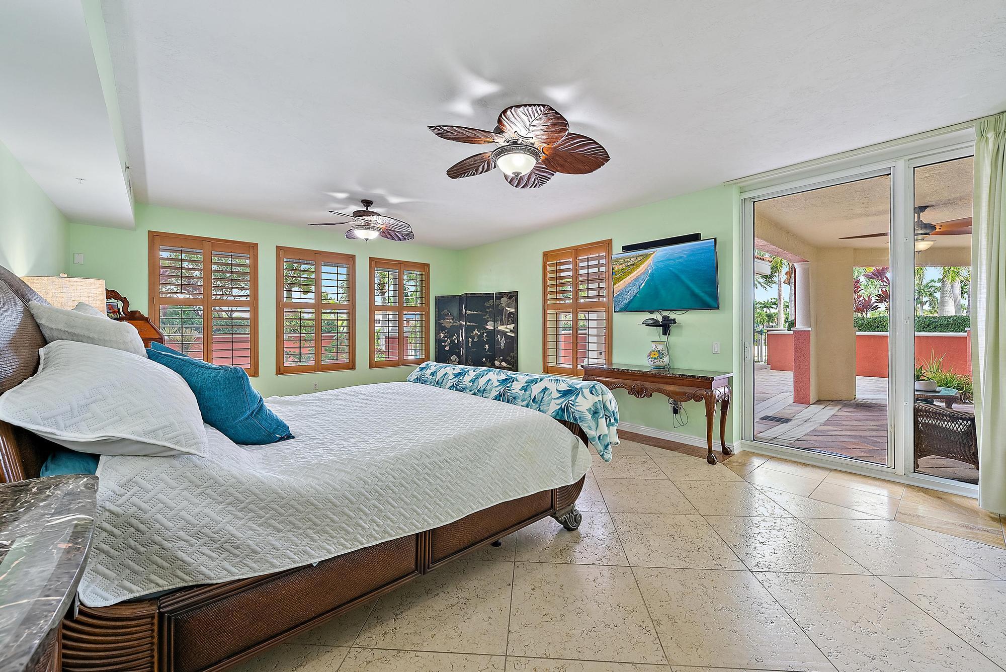400 Highway 1, Unit 104 Jupiter, FL 33477 - Photo 9 of 35 a bedroom with a bed a chandelier and dresser