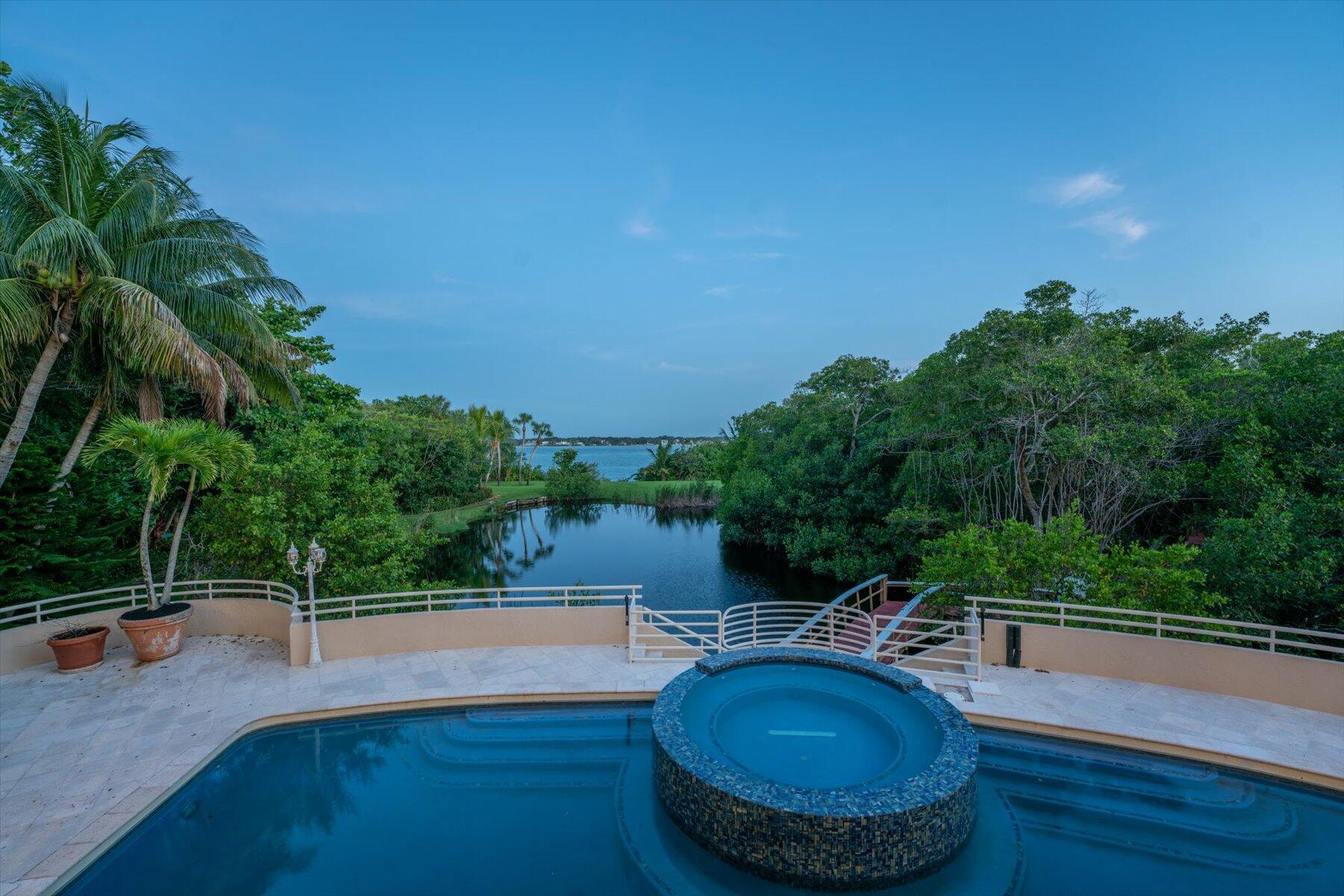 49 West High Point Road Sewall's Point, FL 34996 - Photo 2 of 99 a view of a swimming pool with a patio and yard