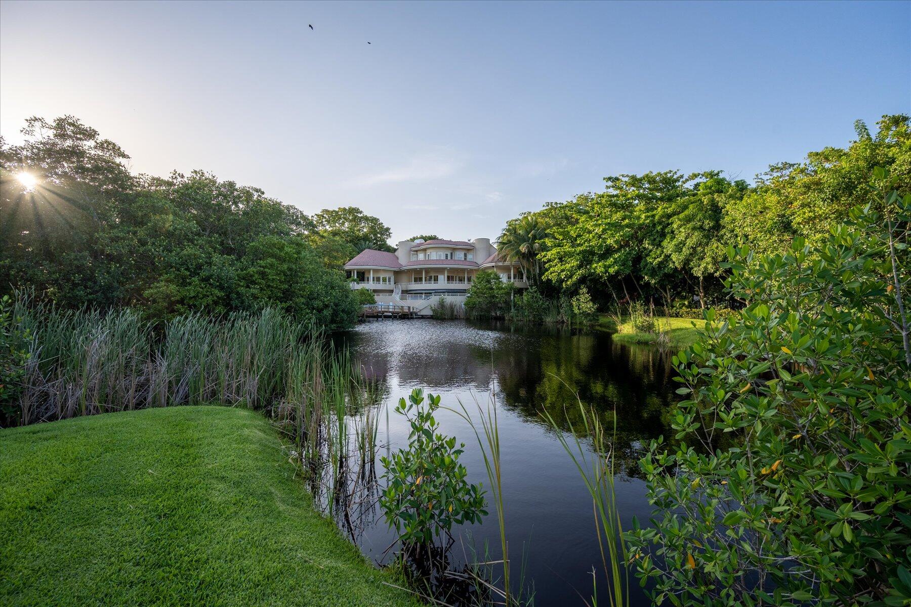 49 West High Point Road Sewall's Point, FL 34996 - Photo 76 of 99 a view of a lake with a house in the background
