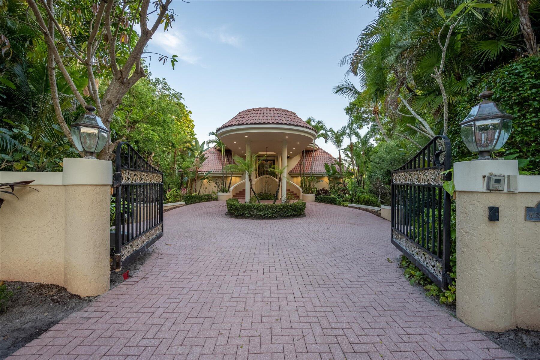 49 West High Point Road Sewall's Point, FL 34996 - Photo 9 of 99 a front view of a house with a garden