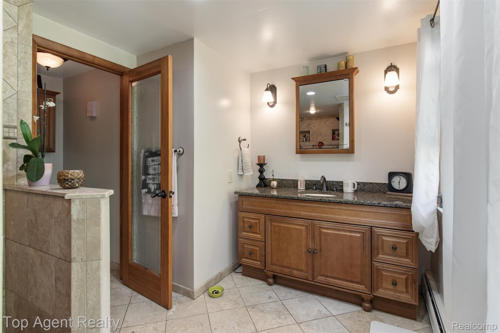 32341 Woody Road Fraser, MI 48026 - Photo 23 of 47 Bathroom featuring a wood vanity with a stone-finish countertop, undermount sink, and wall-mounted sconces