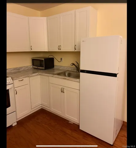 a kitchen with a sink a refrigerator and cabinets