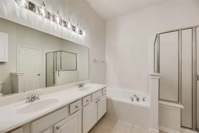 a bathroom with a double vanity sink a mirror and a bathtub