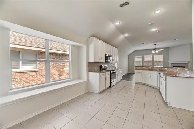 a kitchen with white cabinets and appliances