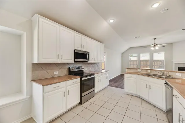 a kitchen with white cabinets appliances and sink