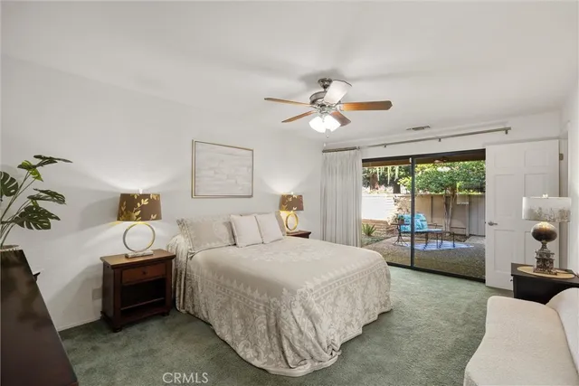 a bedroom with a bed a chandelier and a dresser