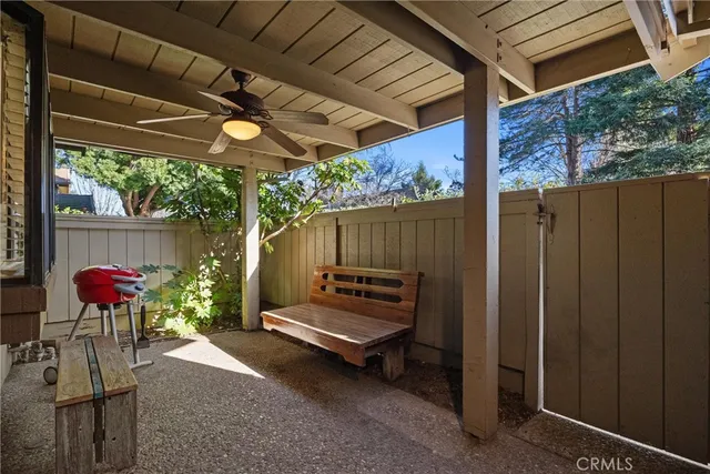 a patio with table and chairs and potted plants