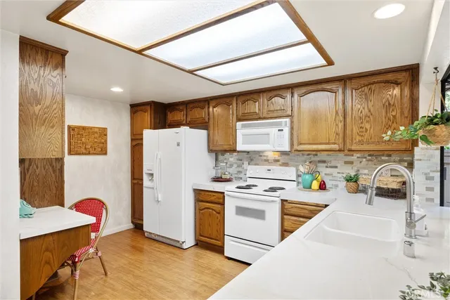 a kitchen with a refrigerator a stove top oven a sink and cabinets