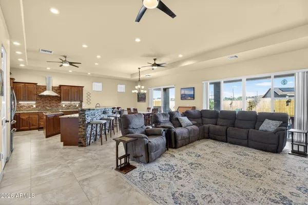 a living room with furniture kitchen view and a chandelier