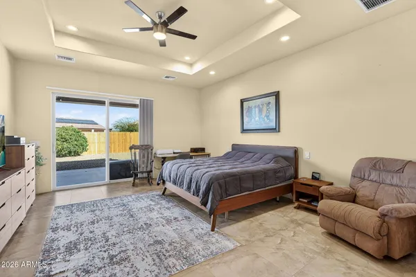 a spacious bedroom with a bed and glass window