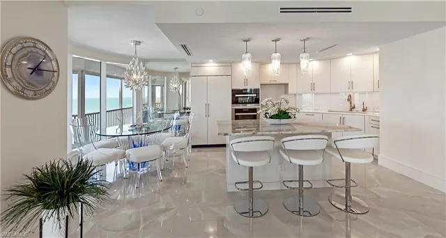 a kitchen with stainless steel appliances a table chairs in it and wooden floors