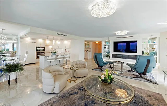 a dining room with furniture a kitchen view and a chandelier