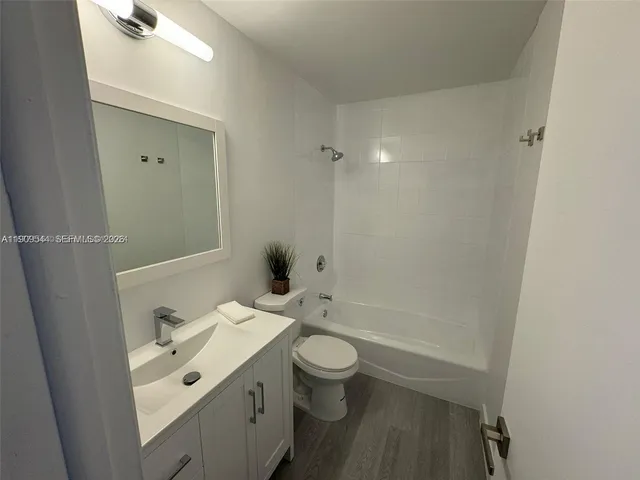 an empty room with wooden floor chandelier fan and windows