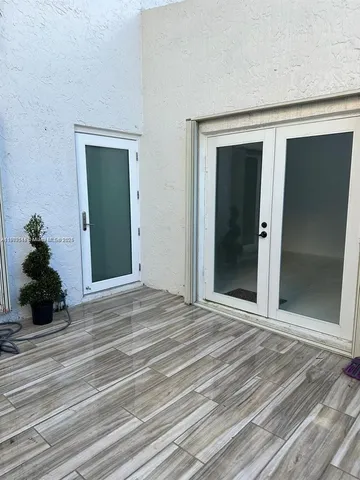a view of a room with wooden floor and a ceiling fan