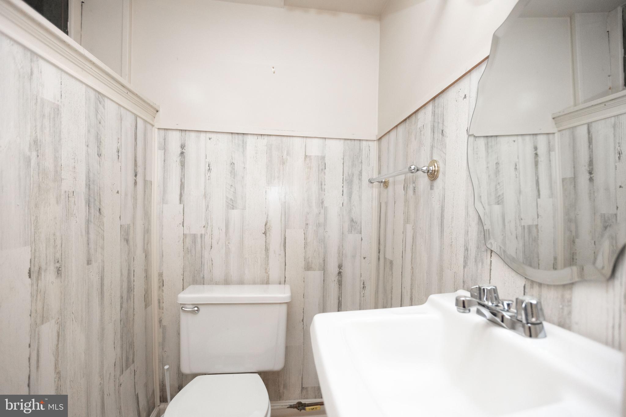 403 Club Road Baltimore, MD 21210 - Photo 54 of 72 a bathroom with a sink a toilet and shower curtain