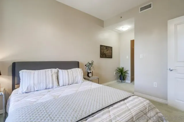 a bedroom with a bed and painting on the wall