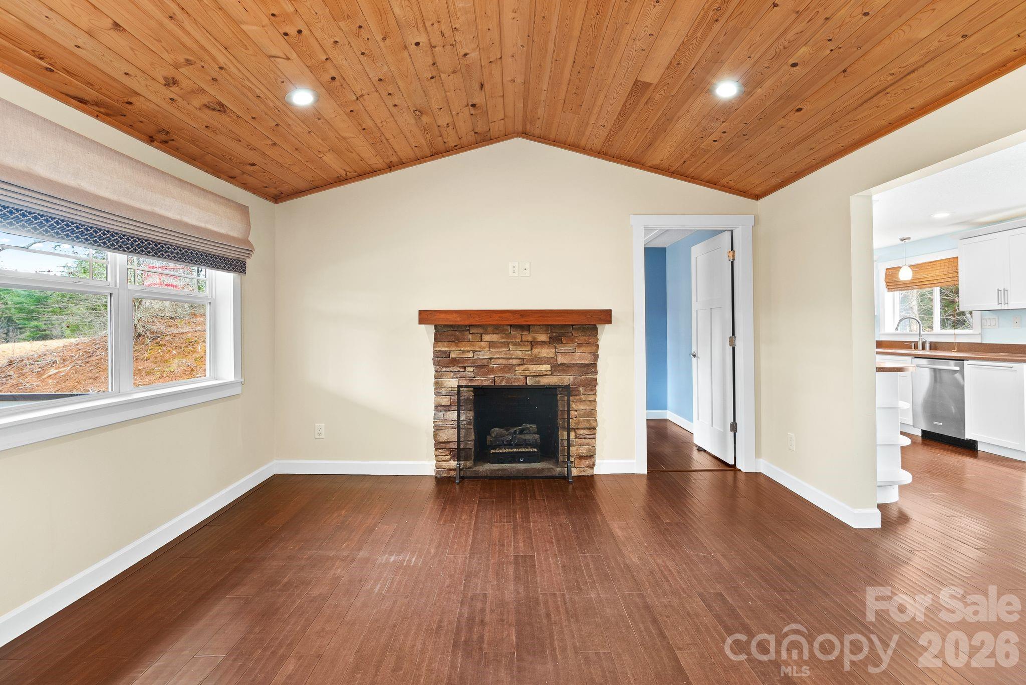90 Palmer Ford Road Weaverville, NC 28787 - Photo 7 of 32 an empty room with wooden floor fireplace and windows