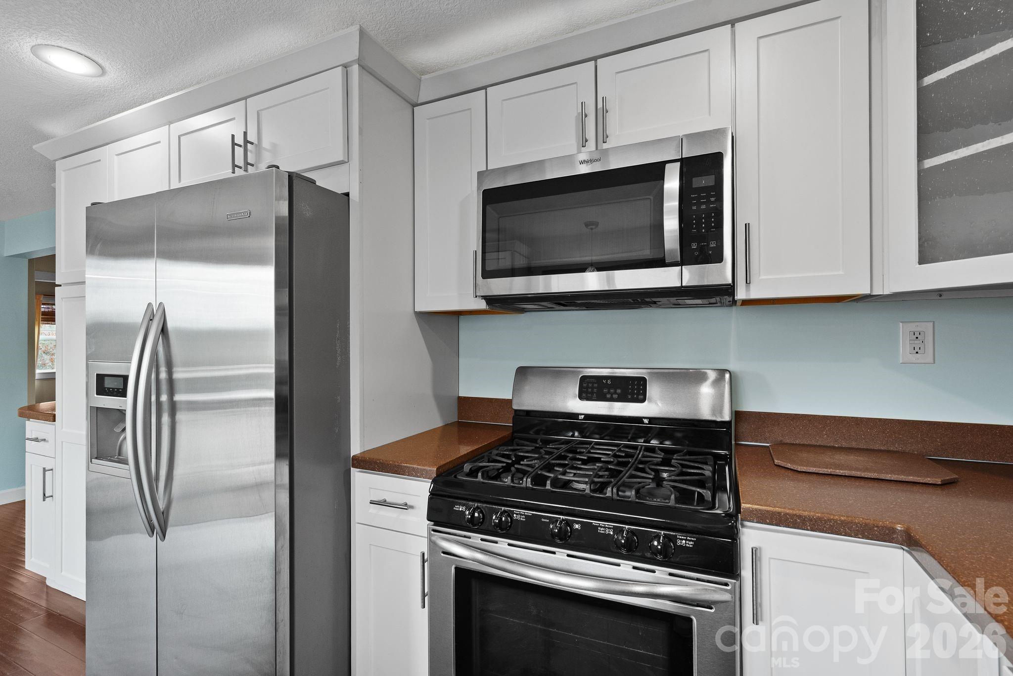 90 Palmer Ford Road Weaverville, NC 28787 - Photo 10 of 32 a kitchen with stainless steel appliances white cabinets and a stove top oven