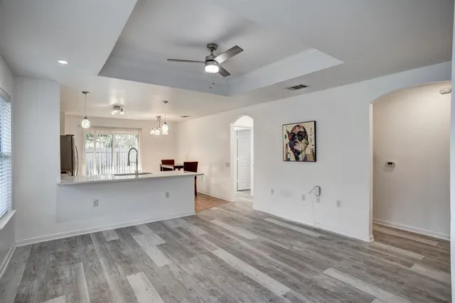 a large white kitchen with a lot of counter space and wooden floor