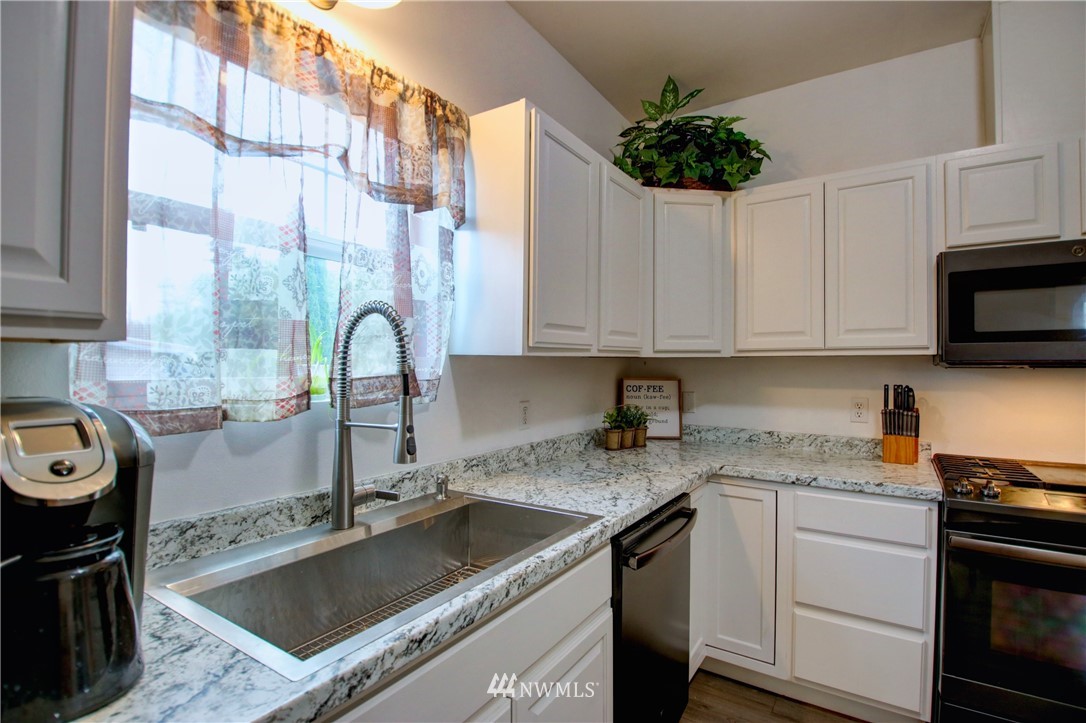 910 Cook Road Sedro-Woolley, WA 98284 - Photo 9 of 37 a kitchen with granite countertop a sink a stove and cabinets