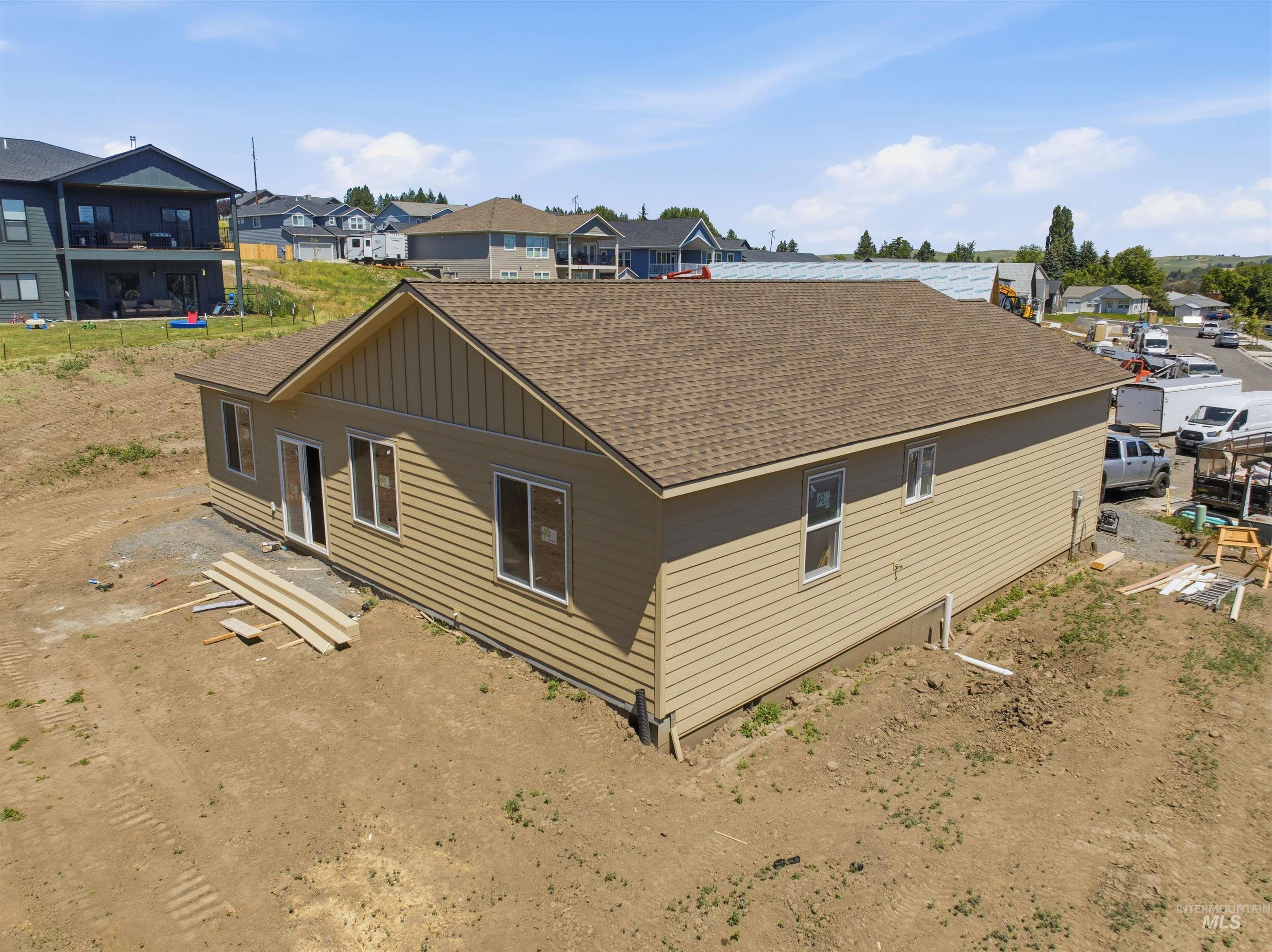 2812 Cyprus Court Moscow, ID 83843 - Photo 15 of 22 Newly constructed residence featuring white horizontal siding, a brown shingle roof with red trim, and an integrated garage