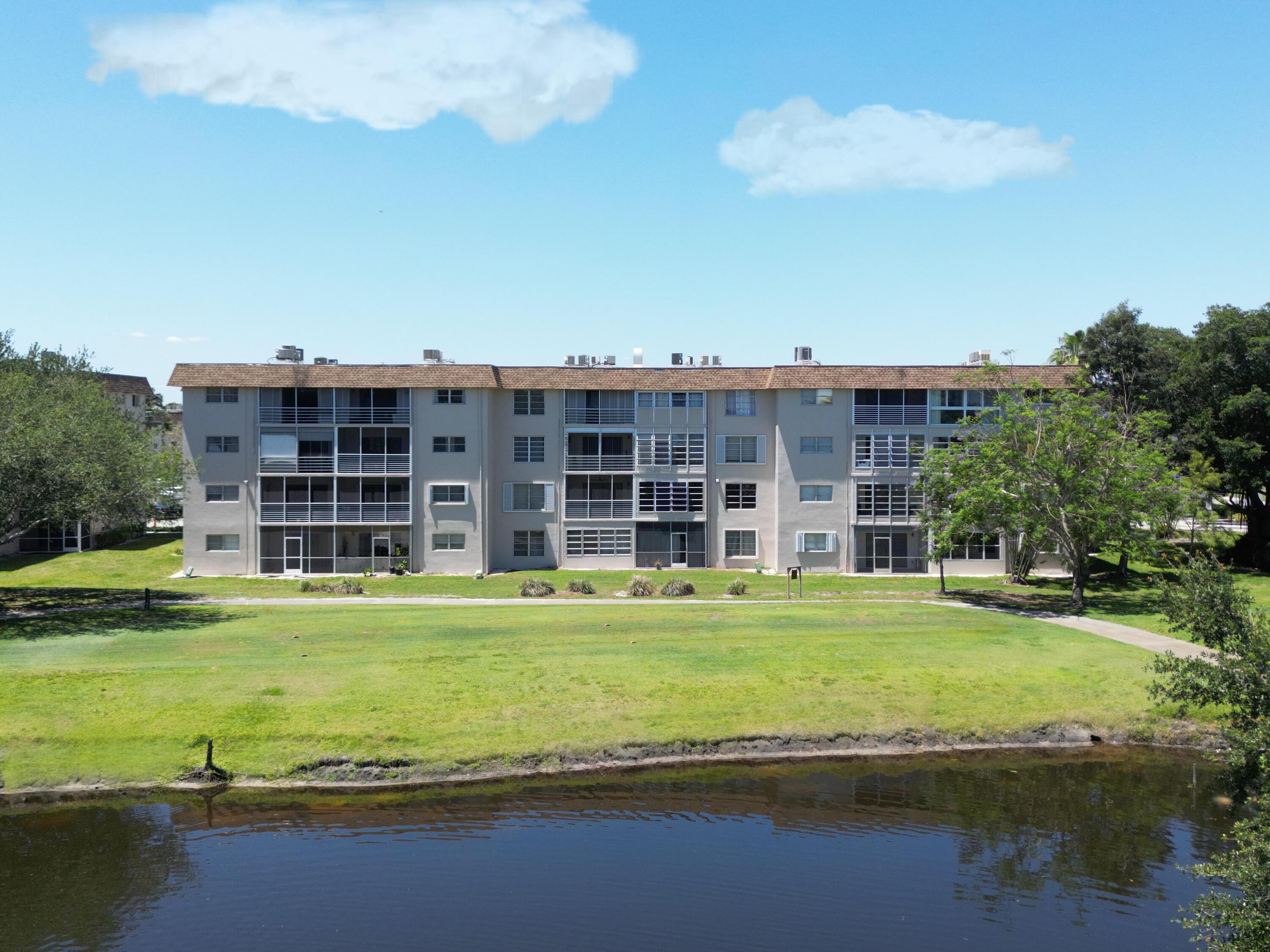 2430 Southwest 81st Avenue, Unit 108 Davie, FL 33324 - Photo 11 of 18 a view of a large building with a big yard and large trees