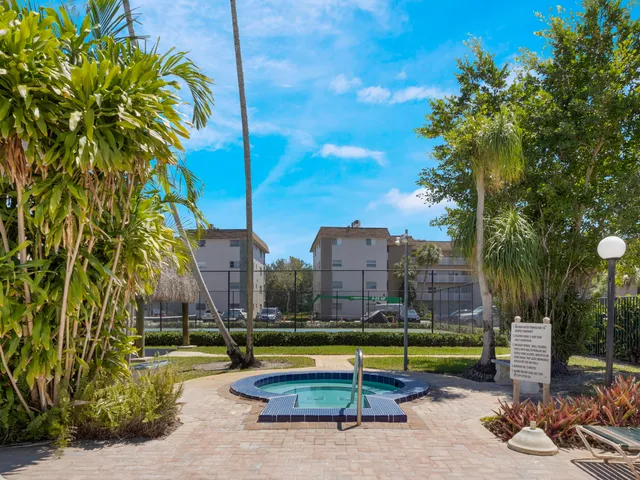 a view of a swimming pool with a lounge chair and palm trees
