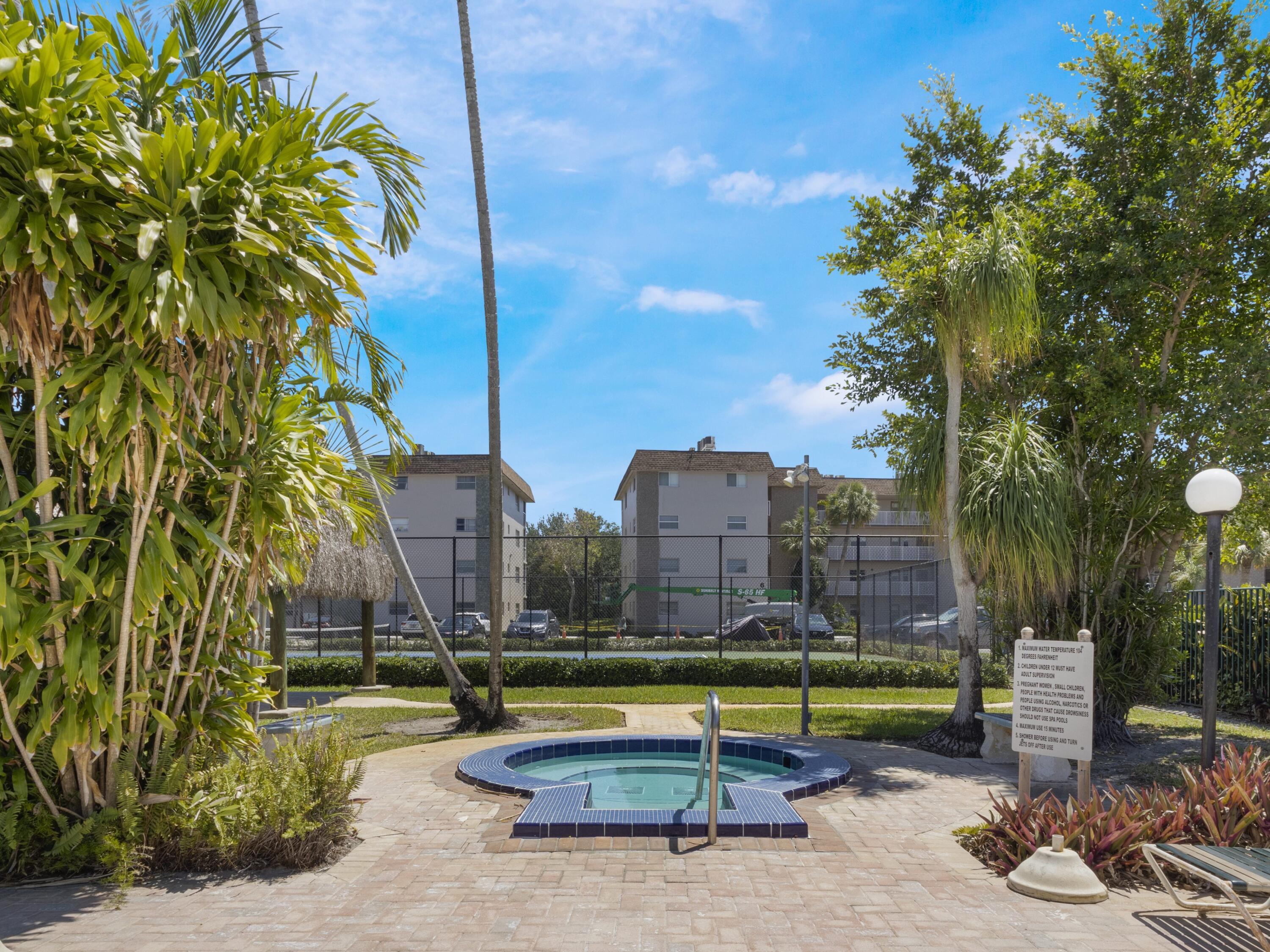 2430 Southwest 81st Avenue, Unit 108 Davie, FL 33324 - Photo 15 of 18 a view of a swimming pool with a lounge chair and palm trees
