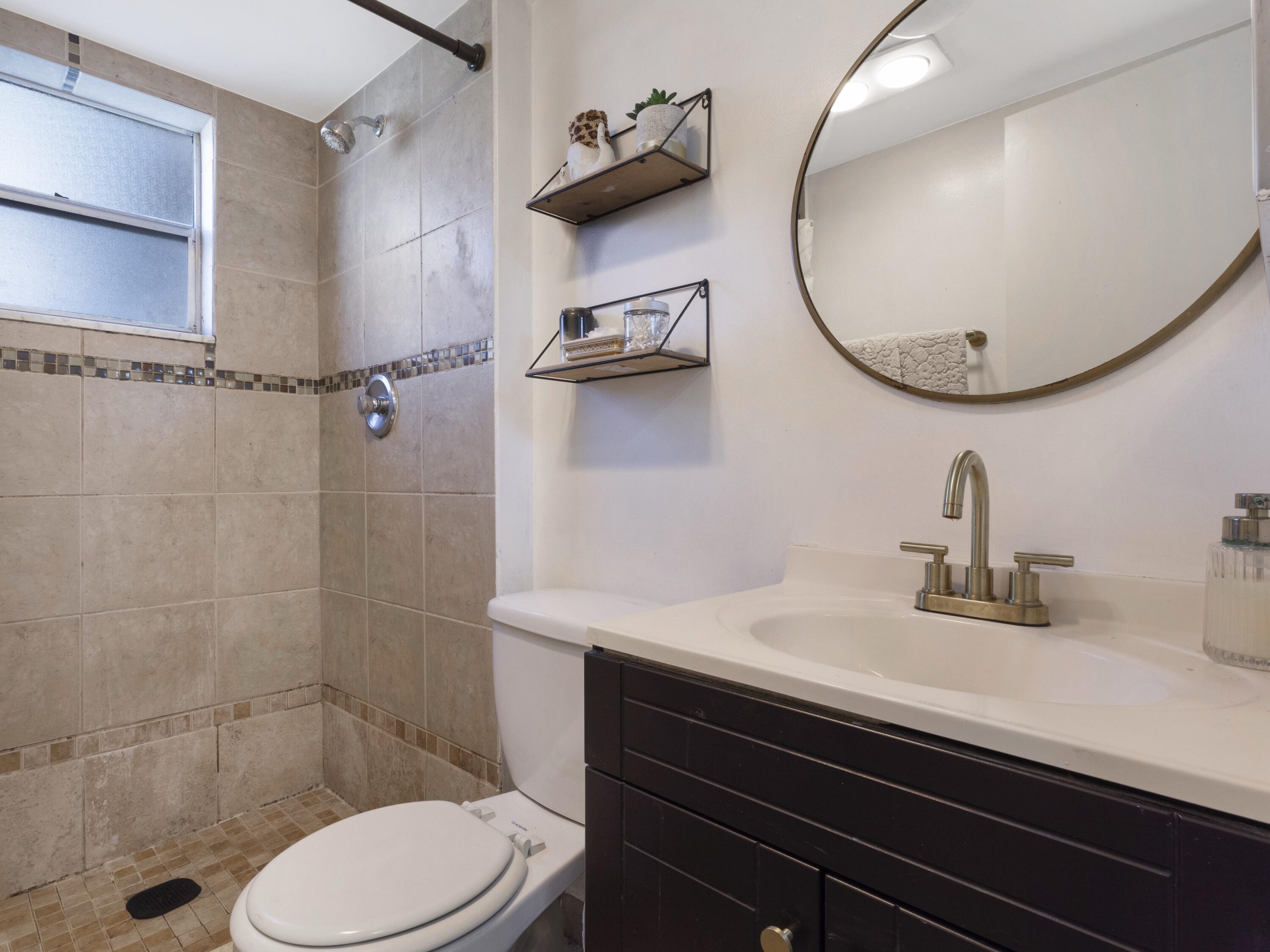 2430 Southwest 81st Avenue, Unit 108 Davie, FL 33324 - Photo 10 of 18 a bathroom with a sink a toilet and a mirror