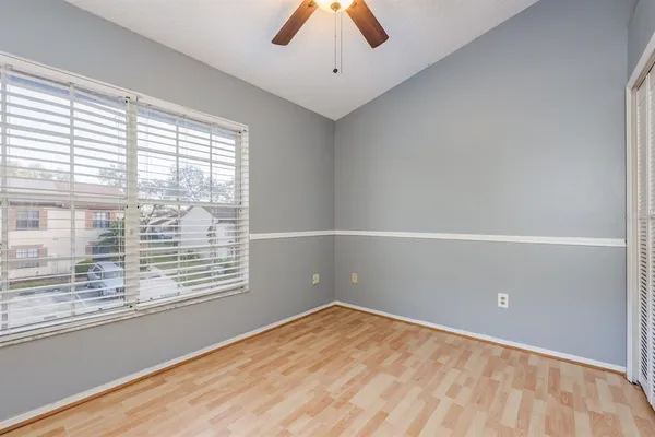 an empty room with closet and windows