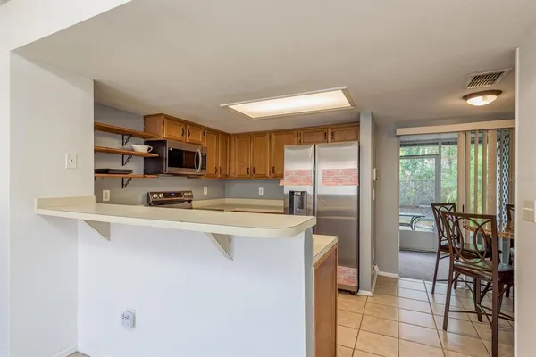 a kitchen with stainless steel appliances a table and chairs in it