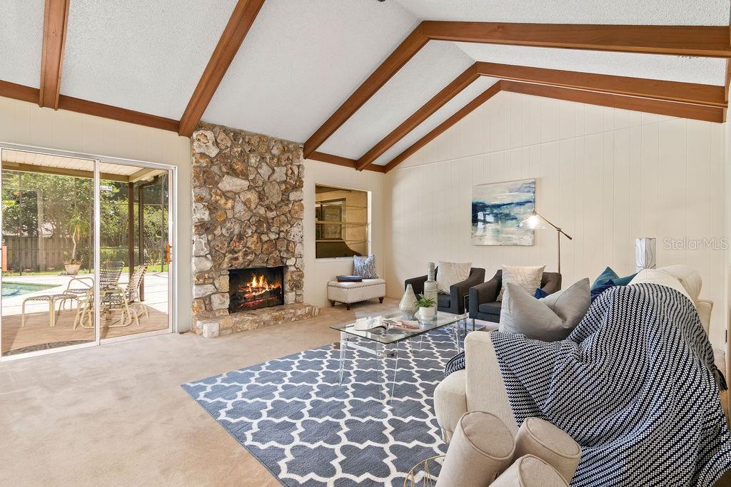 124 Valencia Loop Altamonte Springs, FL 32714 - Photo 10 of 46 Gorgeous family room with vaulted ceiling with wood beams and gas fireplace overlooking the pool with sliding doors