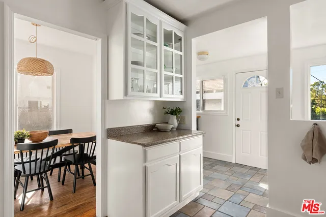 a kitchen with stainless steel appliances granite countertop a table and chairs in it