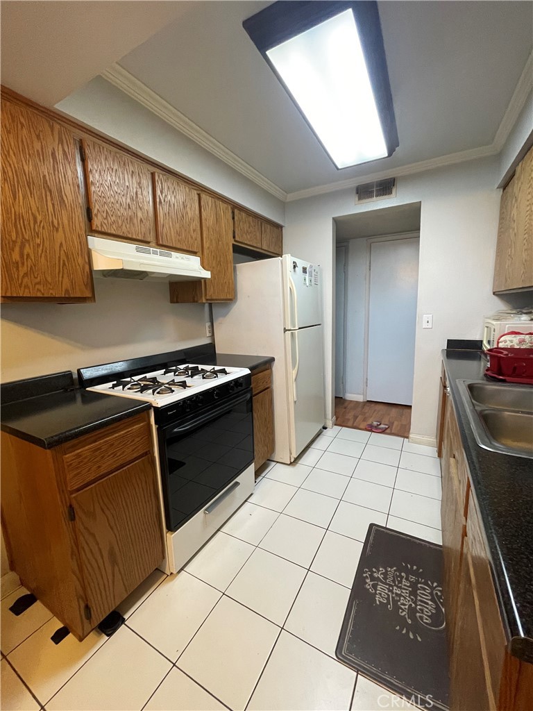 4501 Peck Road, Unit 9 El Monte, CA 91732 - Photo 8 of 17 a kitchen with granite countertop a stove a sink and a refrigerator