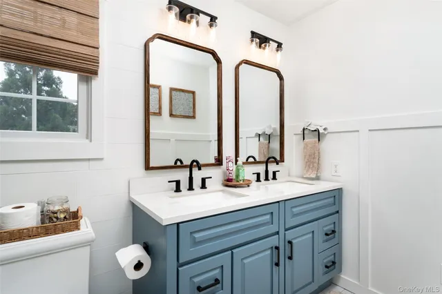 a bathroom with a double vanity sink mirror and toilet