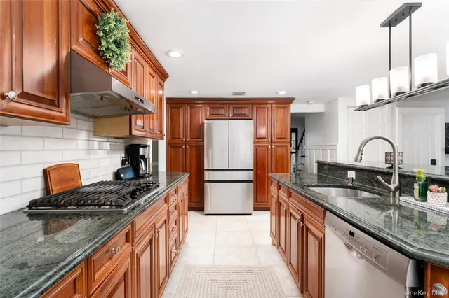 a kitchen with granite countertop a sink stove and refrigerator