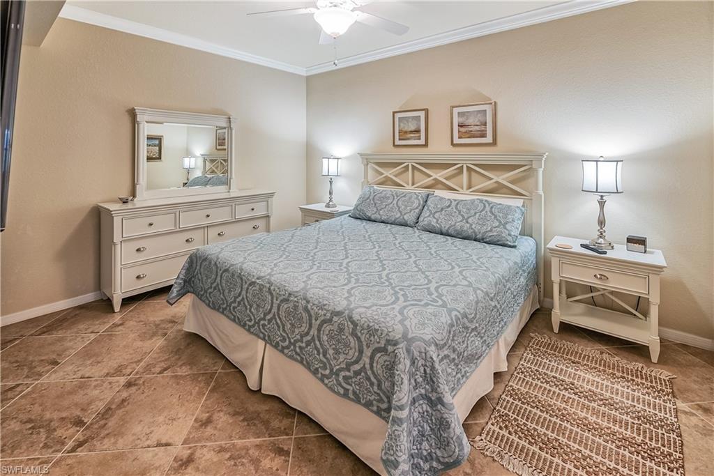 9735 Acqua Court, Unit 622 Naples, FL 34113 - Photo 10 of 34 a bedroom with a bed and a chandelier