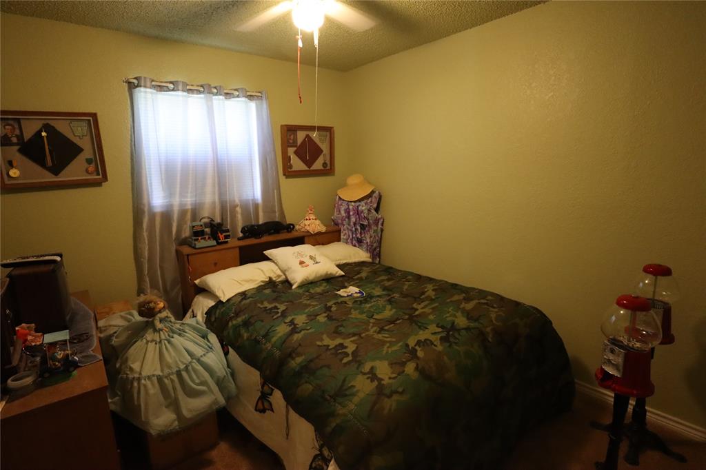 39 Oakcrest Drive Ranger, TX 76470 - Photo 18 of 25 a bed sitting in a bedroom next to a window and a chandelier