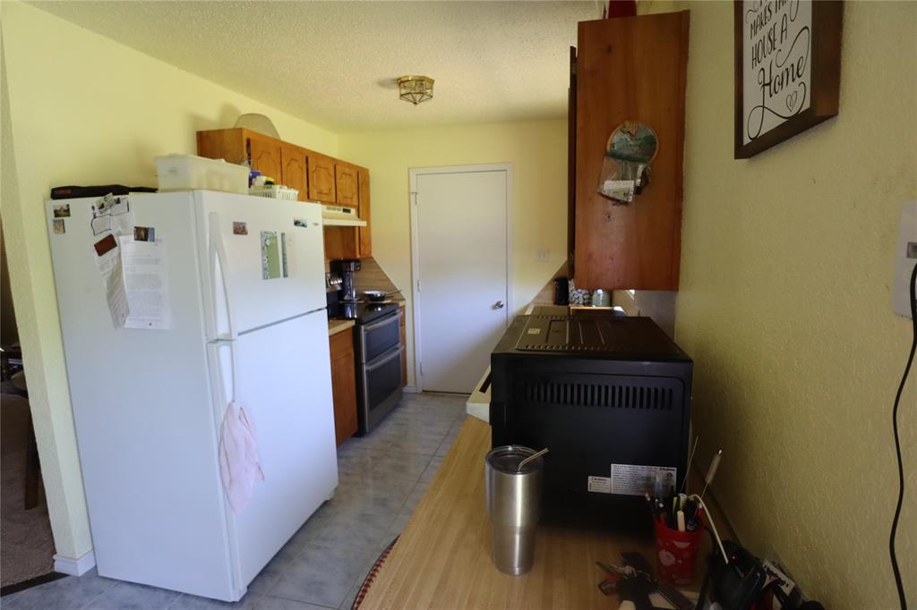 39 Oakcrest Drive Ranger, TX 76470 - Photo 9 of 25 a kitchen with a refrigerator and a stove