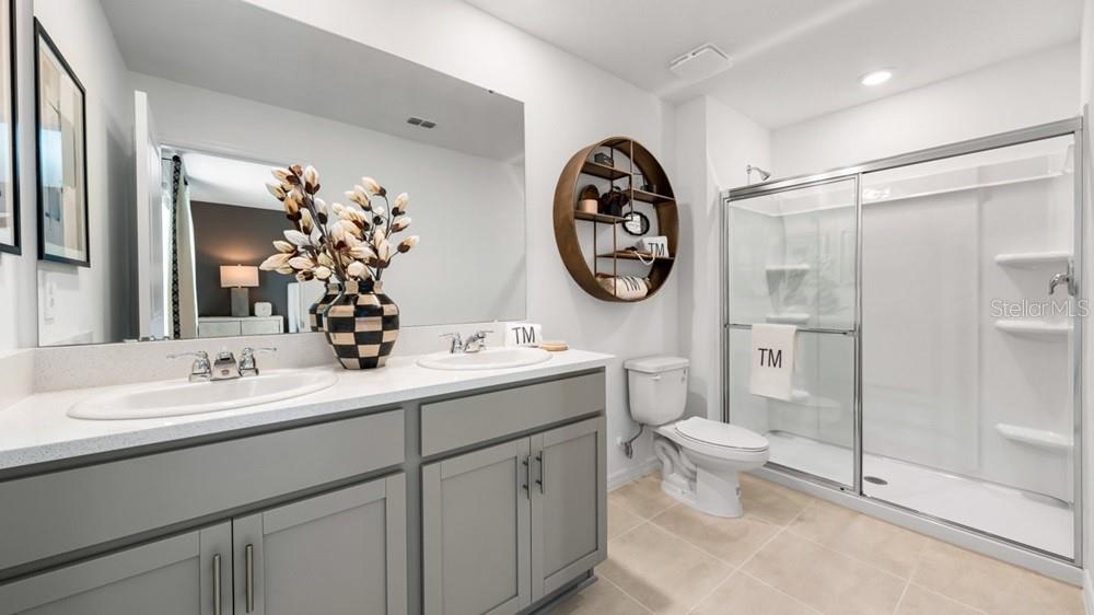 10758 Eclipse Street Sarasota, FL 34241 - Photo 17 of 42 a bathroom with a toilet a sink and glass door