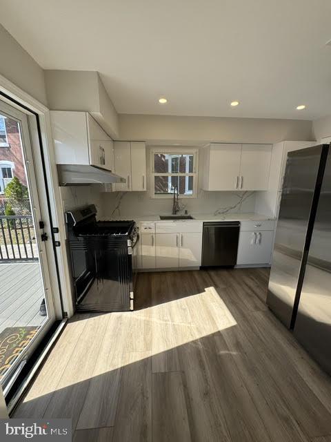104 Stuart Avenue Downingtown, PA 19335 - Photo 4 of 30 a large kitchen with stainless steel appliances a stove a refrigerator a oven a sink with the island and wooden floor