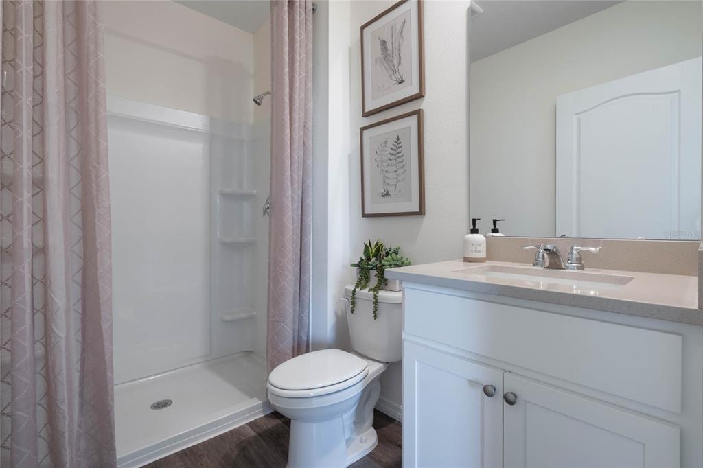 3427 Nettle Loop Tavares, FL 32778 - Photo 16 of 29 a bathroom with a granite countertop sink toilet and shower