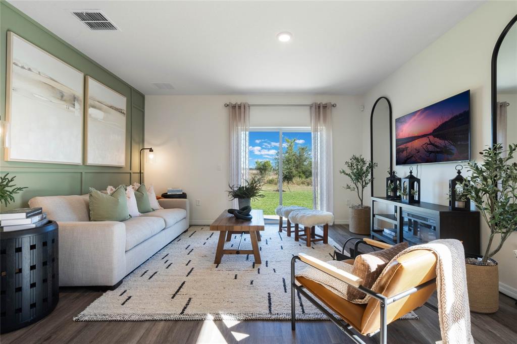 3427 Nettle Loop Tavares, FL 32778 - Photo 7 of 29 a living room with furniture a flat screen tv and a large window